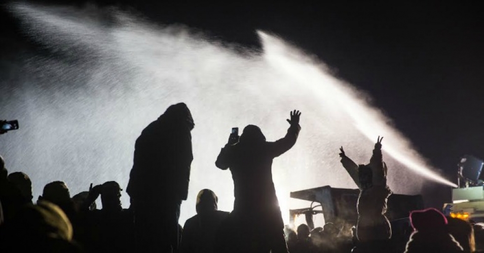 Water protectors stand tall and remain peaceful while law enforcement soaks them with water cannons in below-freezing temperatures. (Photo: Tara Houska/Twitter)