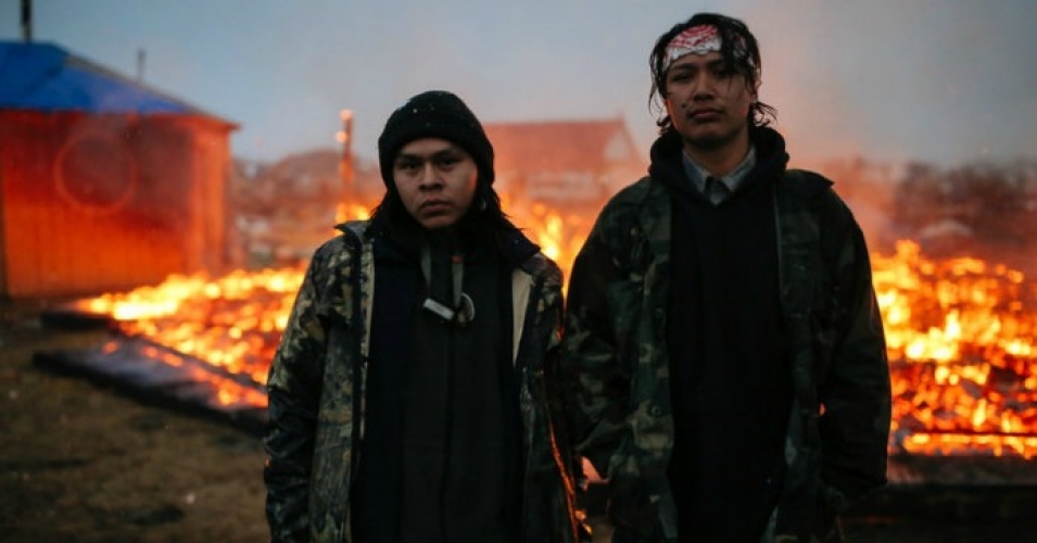 Chanse Zavalla, 22, left, and O'Shea Spencer, 20, right, stand in front of the remains of a hogan structure, set on fire ahead of the U.S. Army Corp of Engineer's deadline to leave the Oceti Sakowin protest camp on February 22, 2017 in Cannon Ball, North Dakota. (Photo: Stephen Yang/Getty Images)