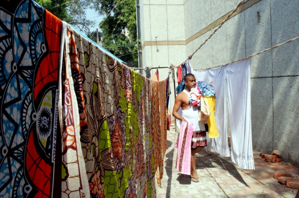 A washerman collecting dried clothes for ironing.