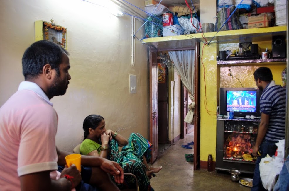 After a long day of work, Ashwani watches television with his mother.