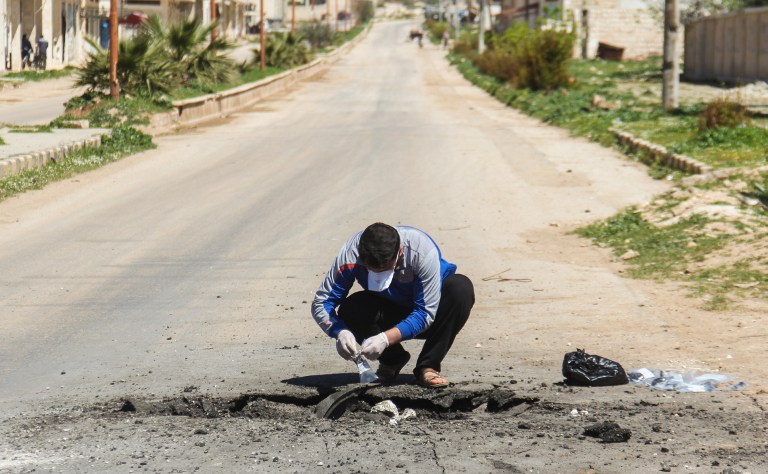A Syrian man collects samples from the site of a suspected toxic gas attack in Khan Sheikhun, in Syrias northwestern Idlib province, on April 5, 2017. International outrage is mounting over a suspected chemical attack that killed scores of civilians in Khan Sheikhun on April 4, 2017. / AFP PHOTO / Omar haj kadour