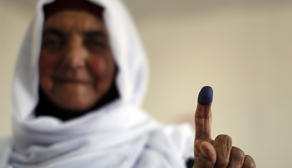 A Palestinian woman shows her ink-stained finger after casting her ballot for municipal elections at a polling station in the West Bank village of Shiyoukh