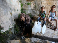 A Palestinian woman fills a jerrican with spring water on June 27, 2016 in Salfit, north of Ramallah, where some of the West Bank village's inhabitants have been without water for days. Tens of thousands of Palestinians in the Israeli-occupied West Bank have gone without water in recent weeks, victims of the latest dispute between Israeli and Palestinian officials over the region's most valuable resource. Photo by Nedal Eshtayah