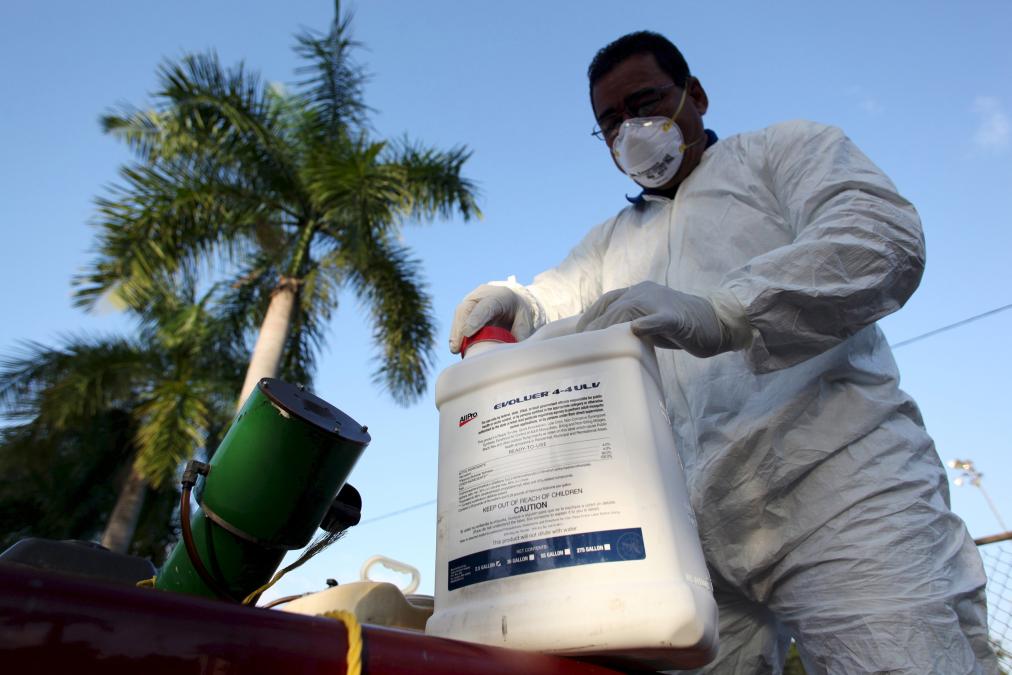 File photo of a health worker preparing insecticide before fumigating a neighborhood in San Juan