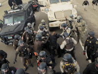 Over 300 police officers in riot gear, eight ATVs, five armored vehicles, two helicopters, and military humvees showed up north of the treaty camp just east of Highway 1806. Photo by Jonathan Klett