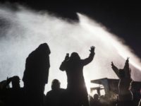 Water protectors stand tall and remain peaceful while law enforcement soaks them with water cannons in below-freezing temperatures. (Photo: Tara Houska/Twitter)