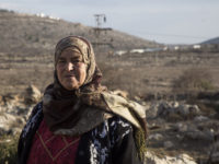 Maryam Hamad, from the West Bank village of Silwad, is pictured with the Israeli Ofra settlement in the background. She is one of the landowners on whose land the nearby Amona outpost was built. According to an Israeli high court decision, the settlers must evacuate this month.  Photo/Keren Manor/ ActiveStills