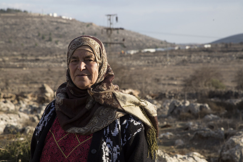 Maryam Hamad, from the West Bank village of Silwad, is pictured with the Israeli Ofra settlement in the background. She is one of the landowners on whose land the nearby Amona outpost was built. According to an Israeli high court decision, the settlers must evacuate this month.  Photo/Keren Manor/ ActiveStills