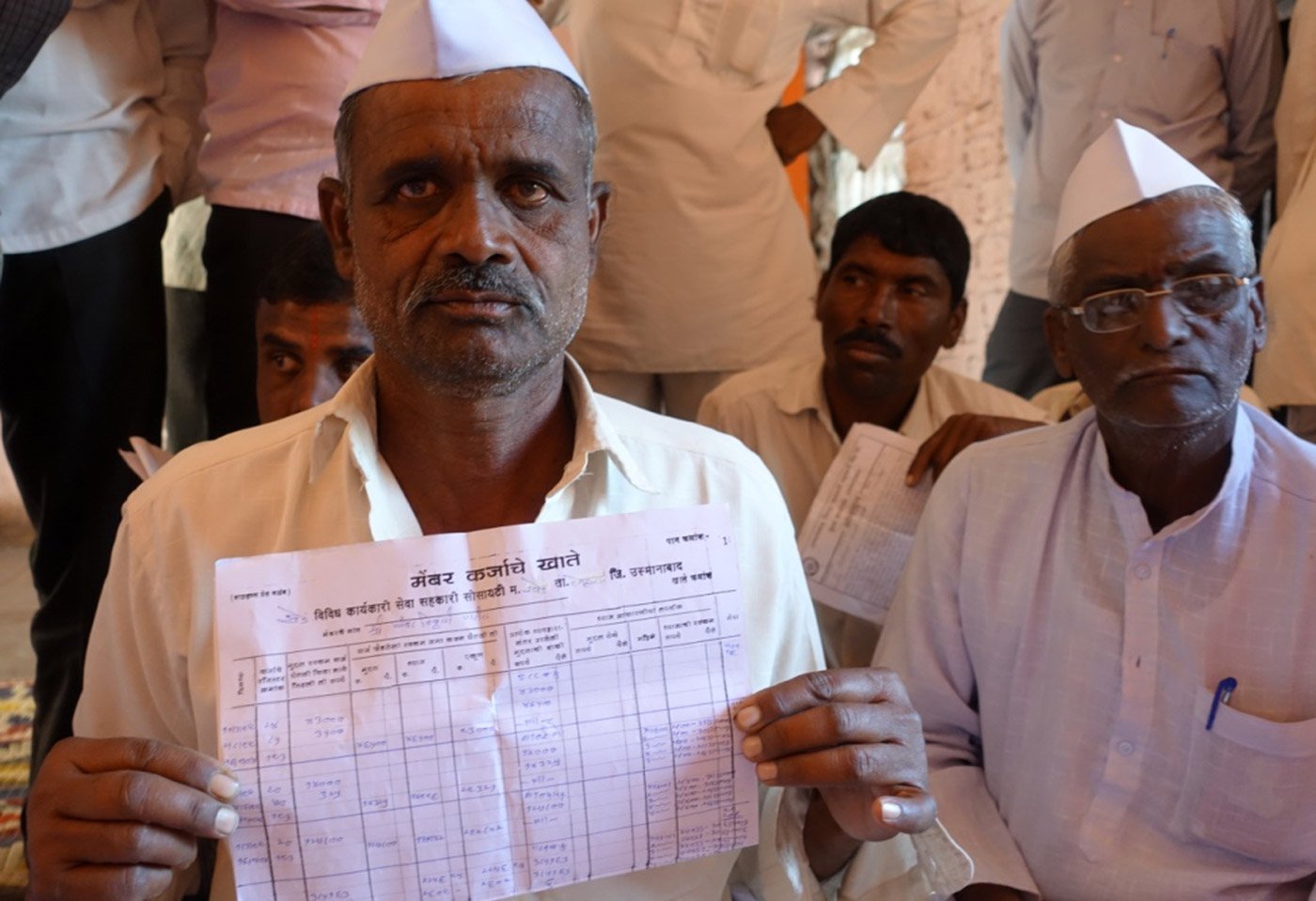 A farmer in Nagur holds up an extract of his loan account from the credit cooperative society; further interest of 2-4 per cent gets added at the level of the societies