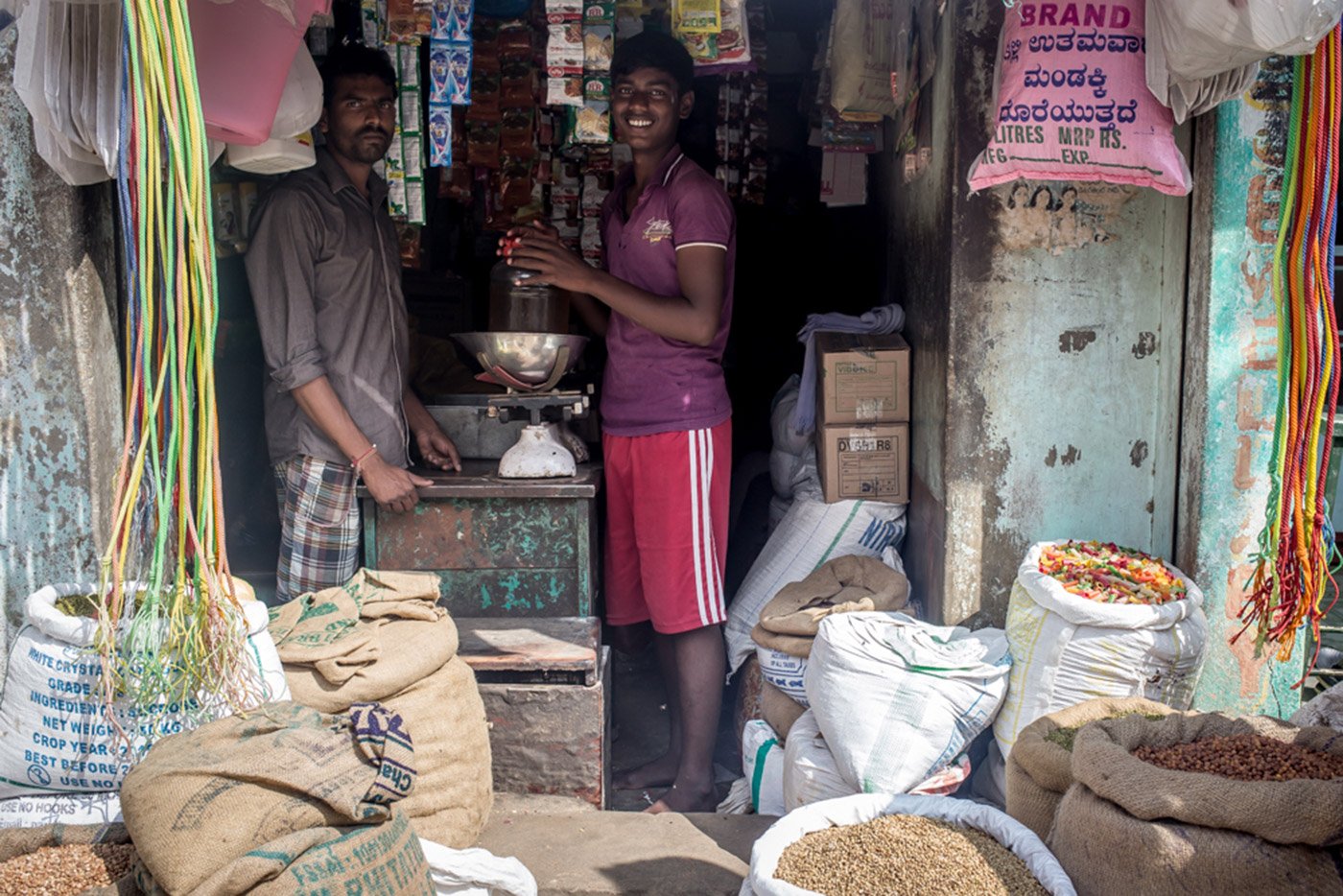 G.R. Raghavendra (left) at his provision store in Roddam village. In November,  he sold less than half the rice he did the previous month to customers hit by the cash crunch 