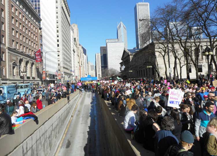 The Chicago Women's March was so large that no one photograph or photographer could have covered the vastness of it (estimated by TV news at a quarter million people, and possibly much more). Above, part of the crowd on Michigan Ave. looking north from the Art Institute (to the right in the photo). Substance photo by Susan Zupan.