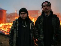 Chanse Zavalla, 22, left, and O'Shea Spencer, 20, right, stand in front of the remains of a hogan structure, set on fire ahead of the U.S. Army Corp of Engineer's deadline to leave the Oceti Sakowin protest camp on February 22, 2017 in Cannon Ball, North Dakota. (Photo: Stephen Yang/Getty Images)