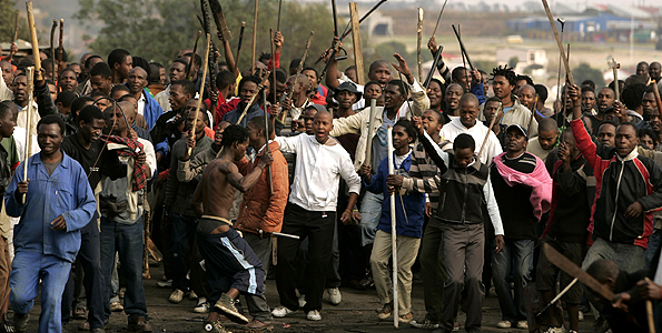 Protesters chant slogans during clashes believed to be linked to recent anti-foreigner violence in Reiger Park informal settlement, east of Johannesburg May 20, 2008. South Africa's police and the ruling ANC party intensified efforts on Tuesday to quell deadly violence against foreigners and a government minister said the unrest could damage the key tourism sector. At least 24 people have been killed in over a week of violent attacks on African migrant workers who are accused by many in South Africa's poor townships of stealing jobs and fuelling a wave of violent crime. REUTERS/Siphiwe Sibeko (SOUTH AFRICA)