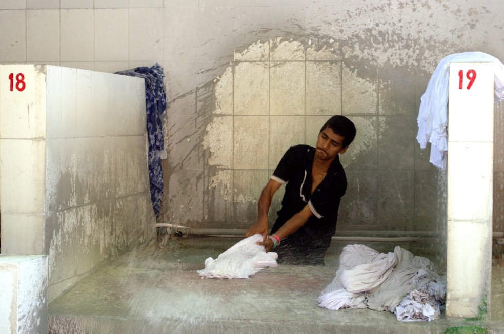 A washerman beating clothes at the Devi Prasad Sadan Ghat.
