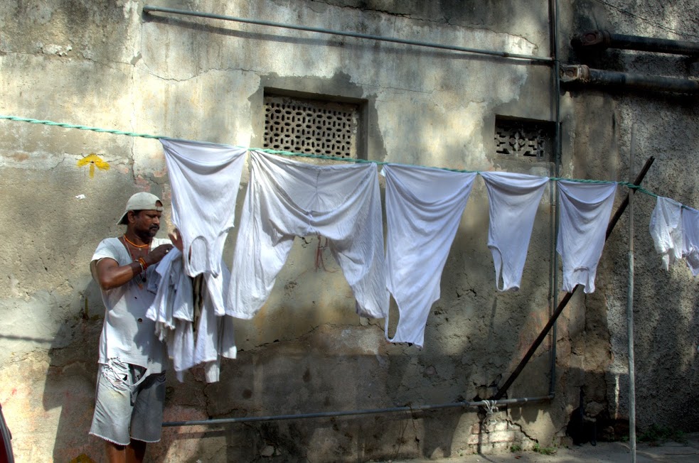 Jaichand, a washerman picks up clothes that have dried in the sun.