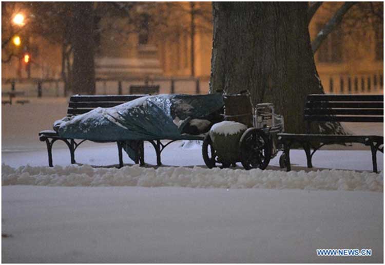 “A homeless sleeps amid a snow storm outside the White House in Washington D.C., capital of the United States…” [Photo: Xinhua/Zhang Jun]