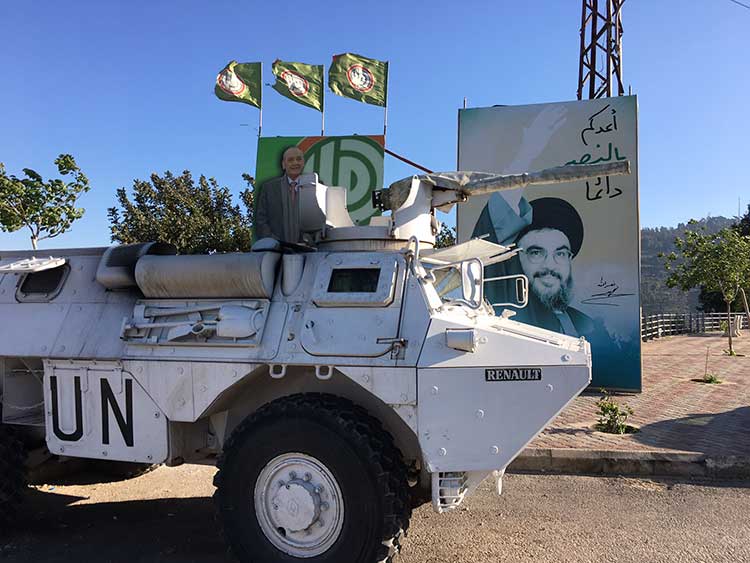 UNIFIL vehicle parked in front of Hezollah poster
