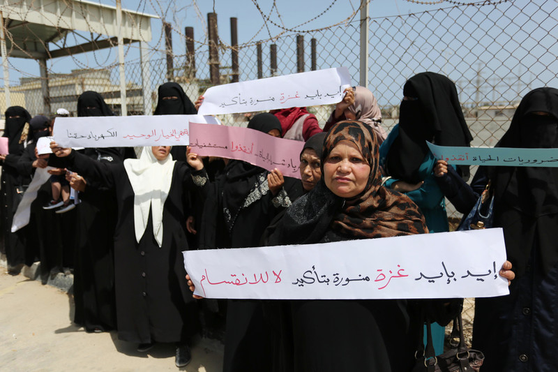 Palestinian women hold banners during a protest calling for an end to intra-Palestinian political divisions that have aggravated the electricity crisis, outside the Gaza Strip’s sole functioning generating plant, 23 April. Ashraf Amra APA images