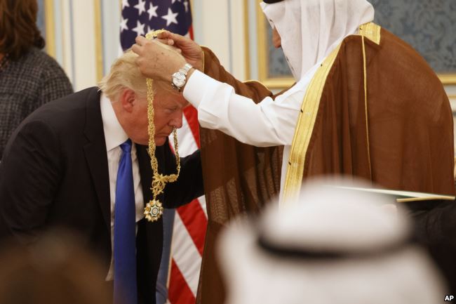Saudi King Salman presents President Donald Trump with The Collar of Abdulaziz Al Saud Medal at the Royal Court Palace, Saturday, May 20, 2017, in Riyadh. (AP Photo/Evan Vucci)