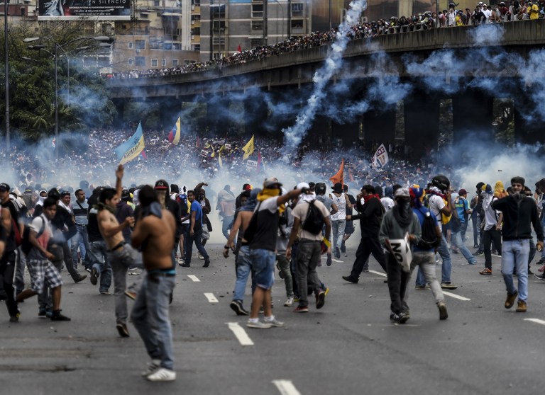 Venezuelan opposition activists clash with the police during a protest against the government of President Nicolas Maduro on April 6, 2017 in Caracas. Violence erupted for a third straight day at protests against the government, escalating tension over moves to keep the leftist leader in power. / AFP PHOTO / JUAN BARRETO