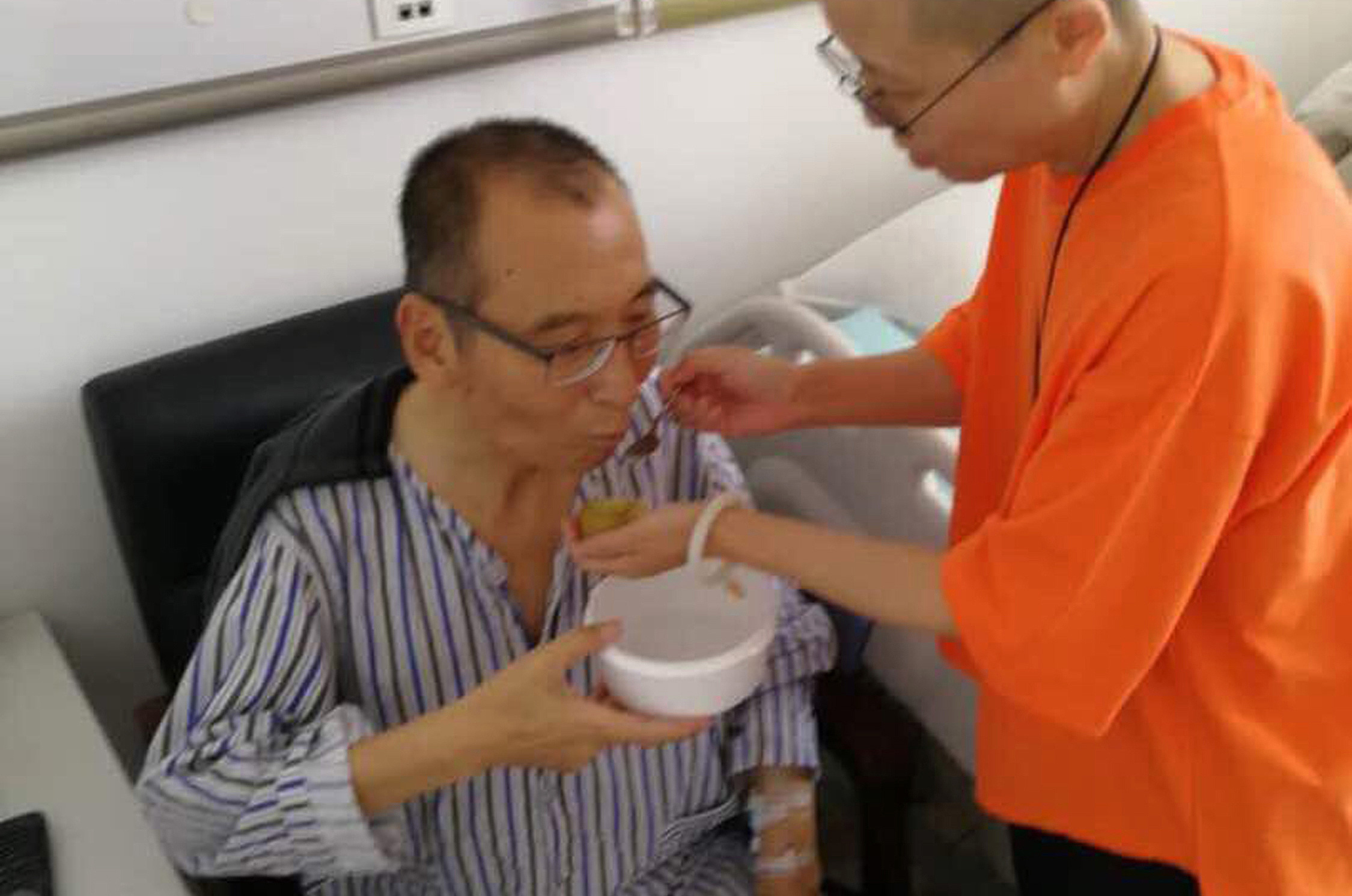 In this undated photo, Liu Xia feeds her husband Liu Xiaobo at a hospital in China. 