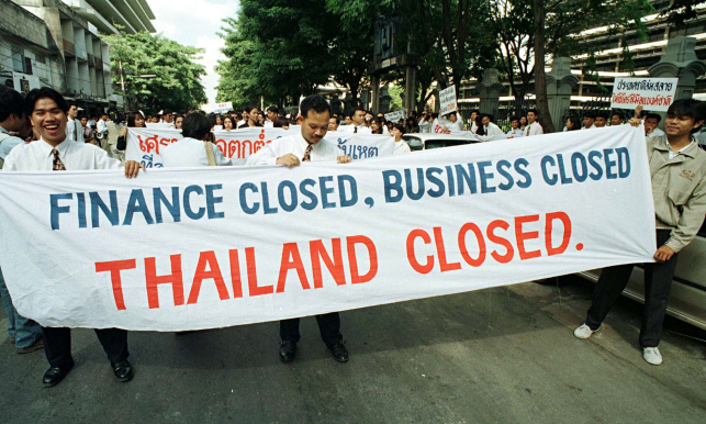 Employees of suspended finance companies carry a banner during a rally in Bangkok in November 1997