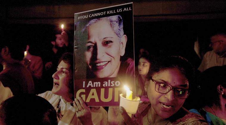 Indian protesters hold candles and placards during a candle light vigil to protest the killing of Indian journalist Gauri Lankesh in Hyderabad, Friday, Sept. 8, 2017. Lankesh's killing has provoked outrage and anguish across the country, with thousands protesting what they see as an effort to silence critics of India's ruling Hindu nationalist party. (AP Photo/Mahesh Kumar A.)