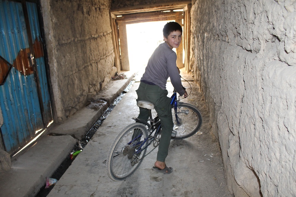 Inaam on his bicycle, near his house and the scene of a suicide bomb attack