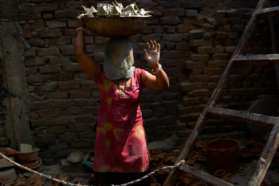 Woman climbing the ladder to and fro, lifting pottery wares.