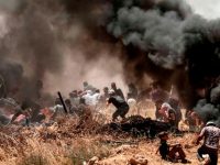 TOPSHOT - Palestinians clash with with Israeli forces near the border between the Gaza strip and Israel east of Gaza City on May 14, 2018, as Palestinians protest over the inauguration of the US embassy following its controversial move to Jerusalem. - Dozens of Palestinians were killed by Israeli fire on May 14 as tens of thousands protested and clashes erupted along the Gaza border against the US transfer of its embassy to Jerusalem, after months of global outcry, Palestinian anger and exuberant praise from Israelis over President Donald Trump's decision tossing aside decades of precedent. (Photo by MAHMUD HAMS / AFP)        (Photo credit should read MAHMUD HAMS/AFP/Getty Images)