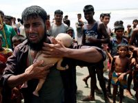 Ahmed, a Rohingya refugee man cries as he holds his 40-day-old son, who died as a boat capsized in the shore of Shah Porir Dwip while crossing ...