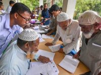 Nagaon: People check their names on the final draft of the state's National Register of Citizens after it was released, at a NRC Seva Kendra in Nagaon on Monday, July 30, 2018. (PTI Photo)   (PTI7_30_2018_000108B)