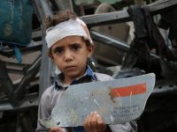 A young survivor of August 9 Saudi-led attack on his school bus, with fragment of U.S. made missile - Photo/Ahmad Algohbarya