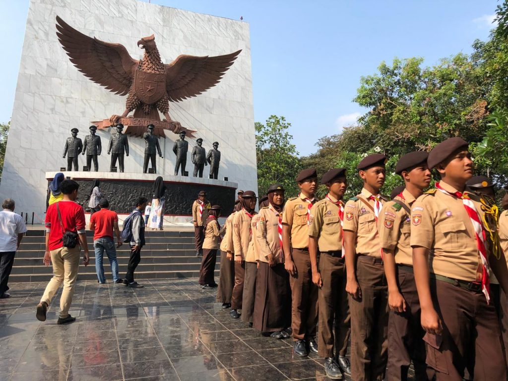 US inspired scouts in front of propaganda monument