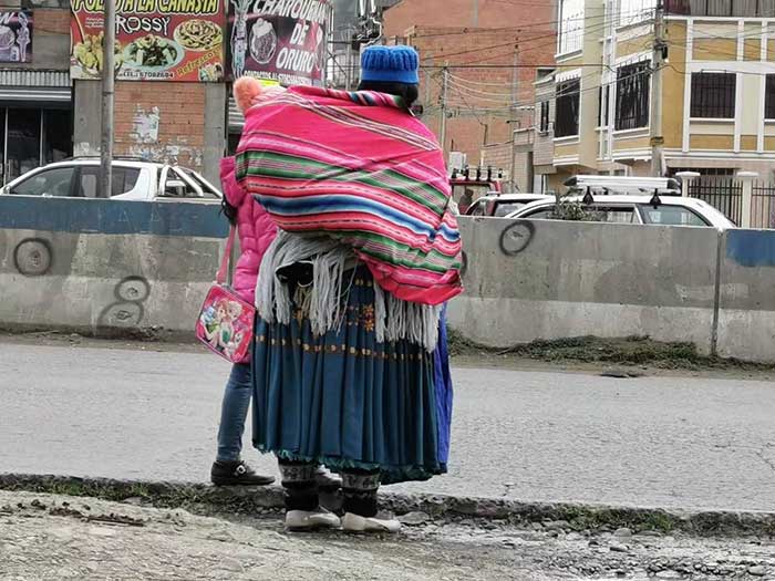 indigenous woman and bullet holes marked in El Alto