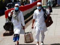 Men wearing protective masks walk as they carry bags, amid concerns about the spread of coronavirus disease (COVID-19), in Nizamuddin, area of New Delhi, India, March 31,  2020. REUTERS/Adnan Abidi