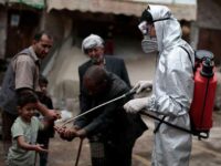 Sanaa, Yemen. 30th Apr, 2020. A health worker wearing a protective suit sprays disinfectant on the hands of people at a market in the old city of Sanaa, amid concerns of the spread of the coronavirus (COVID-19). Photo Credit: Hani Al-Ansi/dpa/Alamy Live News.