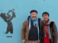 Activists Brian Terrell and Ghulam Hussein Ahmadi at the Border Free Center in Kabul, Afghanistan. Graffiti by Kabul Knight, photo by Hakim