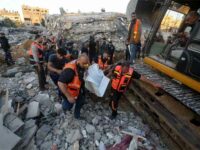 Palestinians recover the body of a Palestinian buried in the rubble of a home destroyed in an Israeli strike in Beit Lahiya, northern Gaza Strip, on 13 May. Atia DarwishAPA images