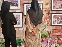 In this photograph taken on April 12, 2023, visitors look at photographs at an exhibition that marks 10 years since the Rana Plaza building collapse disaster, in Dhaka. (Photo: Munir Uz Zaman/AFP via Getty Images)