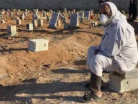 A man sits by the graves of the flash flood victims in Derna, Libya, Friday, September 15, 2023. [AP Photo/Yousef Murad]